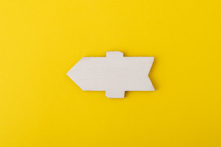 White wooden direction sign on yellow background. Direction Signs. Copy space. Mock up.の写真素材