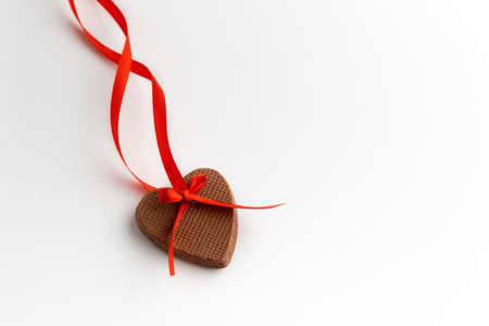 Heart shaped gingerbread cookie with red ribbon on over white background. Valentines day.の写真素材