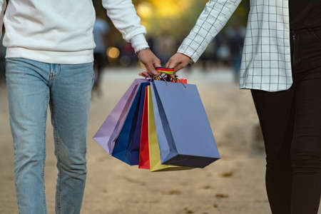 Couple in love carries multi-colored paper shopping bags. Shopping together.の写真素材