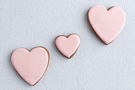 Valentines day treat. Homemade ginger heart-shaped cookies with icing sugar on white backgroundの写真素材
