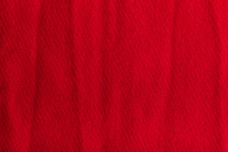 Textured background from red woolen fabric. Crumpled surface.