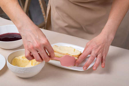 Process of making cake with vanilla cream. Pastry chef hands preparing cake.の写真素材