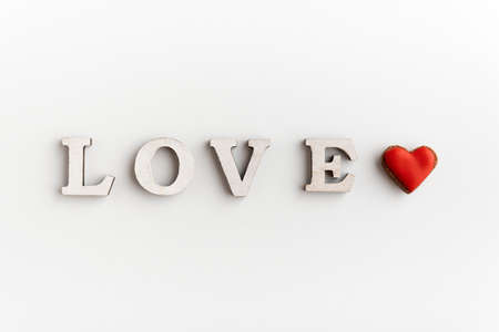 White inscription LOVE on a white background and a small heart. Valentines dayの写真素材