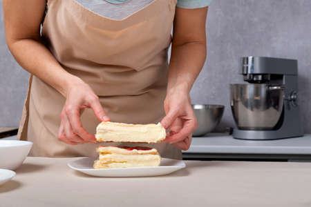 Woman chef prepares pie with vanilla and fruit cream. Hands of confectioner.の写真素材