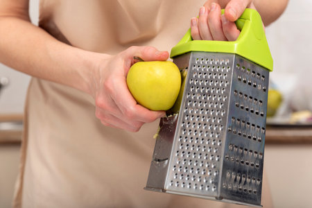 Chef grates an apple to make an apple pieの写真素材