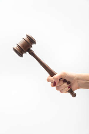 Judge gavel in female hand on white background. Woman judge concept. Vertical frame.の写真素材