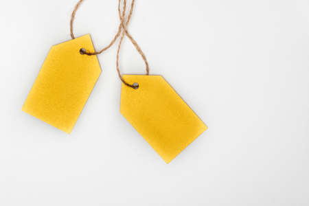 Yellow clothing tags on white background. Labels blank mockup template.の写真素材