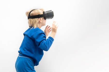 Child is playing virtual reality game. Boy in VR glasses. White backgroundの写真素材