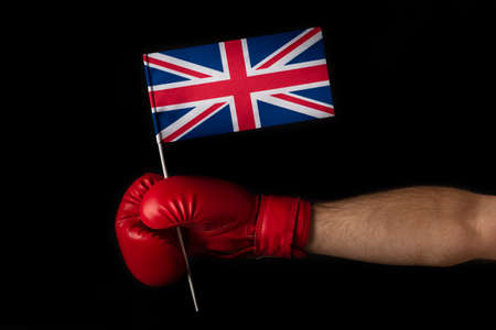 Boxer hand holds flag of Great Britain. Boxing glove with the Great Britain flag. Black backgroundの写真素材