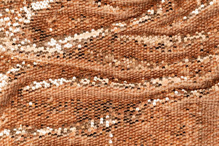 Golden shiny background, fabric background with sparkle. Sequins on the textile with folds.の写真素材