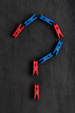 Clothespins in the form of question mark on black background. Question mark made from colorful clothespins.の写真素材