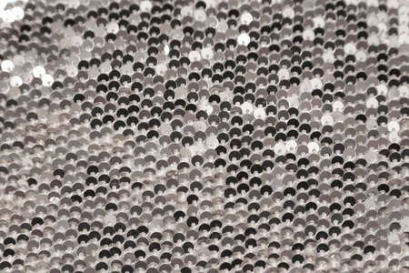 Abstract shiny background. Fabric with silver sequins. Sequins. Textile. Close up
