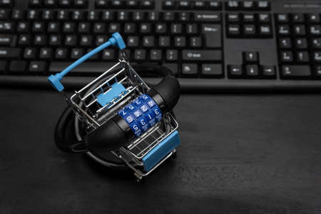 Shopping cart with combination lock, computer keyboard on background. Online shopping securityの写真素材