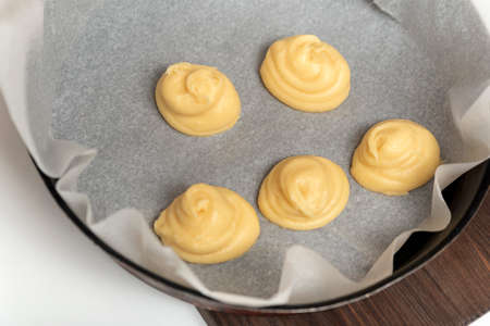 Process of making profiteroles, eclairs. The dough is on baking sheet. Homemade pastry.の写真素材