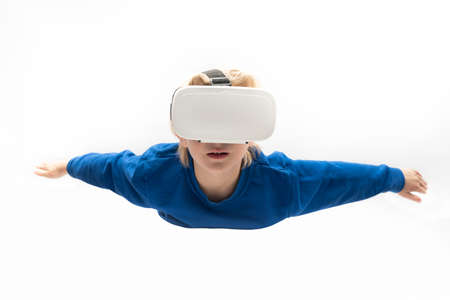 Boy in virtual reality glasses flies on white background. Virtual reality games, VR glasses.の写真素材