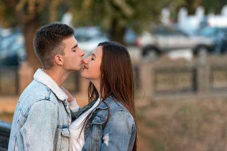 Guy gently kisses his girlfriend in the nose. Portrait of loving couple. Romantic date in the cityの写真素材