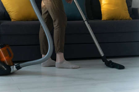 Housekeeper is cleaning up the house.Woman is cleaning the apartment. Cleaning lady vacuums floorの写真素材