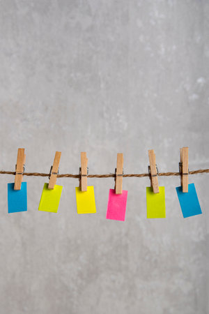 Bright small notes hang with clothespins on rope. Copy space. Place for your text. Vertial frameの写真素材
