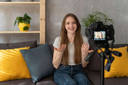 Beautiful girl is recording something for a video blog. Young blogger speaks and films himself. ......