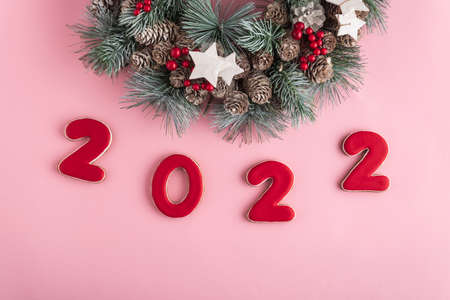 2022 new year from gingerbread and Christmas wreath on pink background. Happy New Year 2022.の写真素材