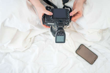 Female photographer holds camera with flash. Top view. SLR camera. Photographers equipment