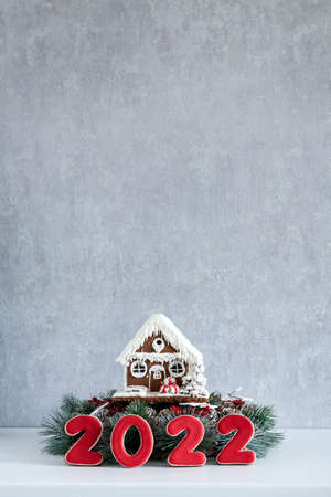 Gingerbread house and Inscription 2022. Merry Christmas background, copy space. Light gray wall on...