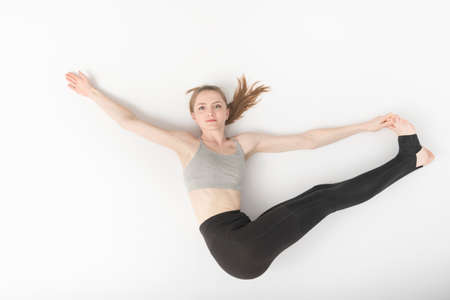 Young woman is engaged in gymnastics. Development of flexibility. Asanas in yoga. Beautiful slender...