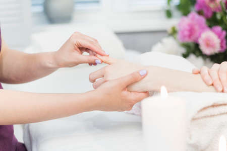 Woman gets hand massage in spa salon. Hand skin care procedures. Relaxing massage in beauty salonの写真素材