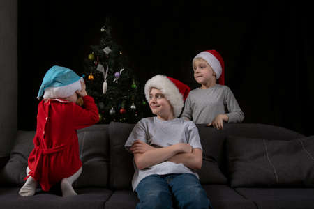 Children are waiting for Christmas gifts. Three children in Santa hatsの写真素材