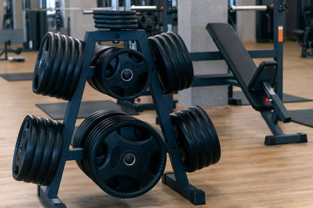 Rack for storing discs for barbells and dumbbells. Sports equipment. Modern gym