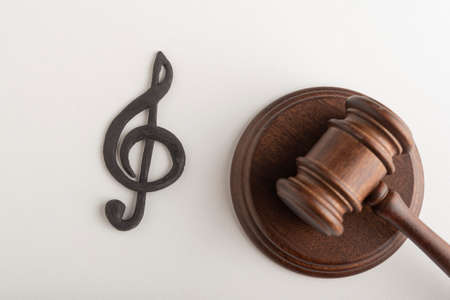 Treble clef symbol and judges hammer. Violation of music copyright. Digital piracy