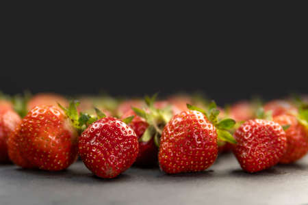 Close up ripe juicy strawberries on black background. Place for your text. Copy spaceの写真素材