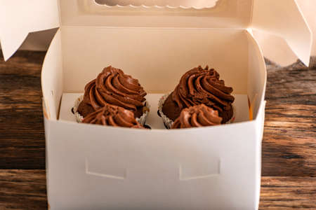 Homemade chocolate cake with chocolate glaze in box. Delivery of desserts. Muffins in the packageの写真素材