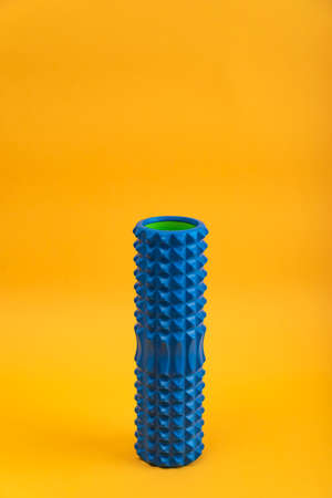 Tools for self-massage on yellow background. Foam roller for myofascial release. Massage roller....