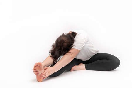 Woman does gymnastics and performs an exercise to develop flexibility. Portrait of girl practicing...