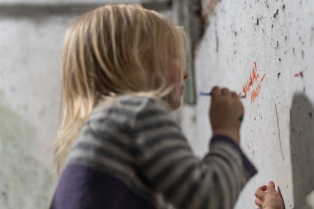 KHARKOV, UKRAINE- 3 MARCH 2022: Ukrainian girl writes on wall NO WAR hiding in bomb shelter. Children in basements are fleeing from shelling by Russian soldiersのeditorial素材