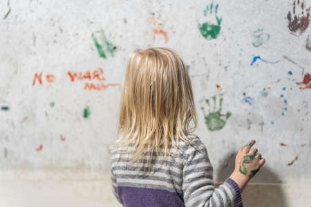 KHARKIV, UKRAINE- 3 MARCH 2022: little Ukrainian girl paints on wall in basement hiding from bombing and artillery shelling by Russian troopsのeditorial素材