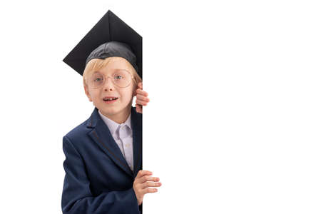 Portrait of blond schoolboy in school uniform and students hat peeks out. Place for your text. copyspace. Isolation on white backgroundの写真素材