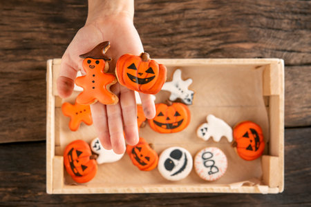 Homemade gingerbread for Halloween on palm. Cookies in the form of jack-o-lantern and ghosts. Preparation for Halloween.の写真素材