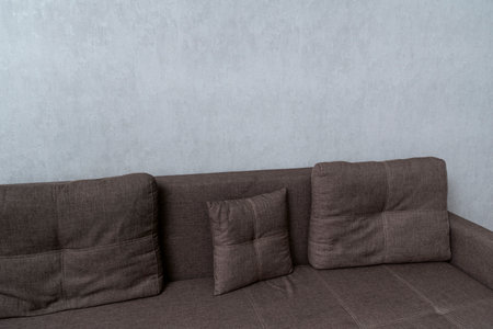 Brown gray sofa against a white wall. Upholstered furniture. Couch with cushions in the living roomの写真素材