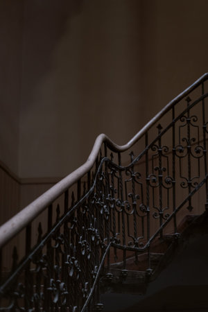 Openwork vintage staircase in an old house. Architecture of the 19th century. Forged railings. vertical frameの写真素材