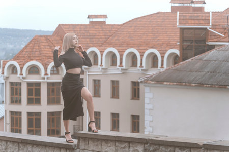 Young sexy woman stand on ancient architecture background. Stylish woman in black outfit and heelsの写真素材