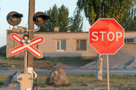STOP sign near the railway crossing. Rules of the road. Level crossing sign. Caution sign about hazard and train trackの写真素材
