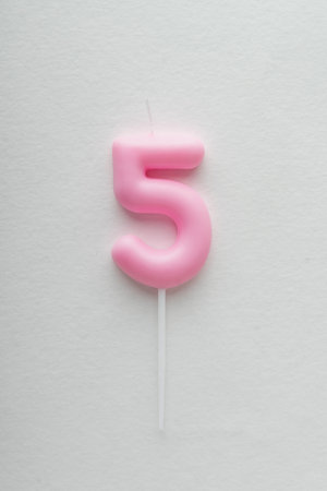 Number 5 birthday candle on white background. Top view. Copy space. Vertical frame.の写真素材