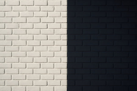 Half of a white brick wall enveloped in a dark shadow, creating a striking contrast that emphasizes the texture and structureの素材