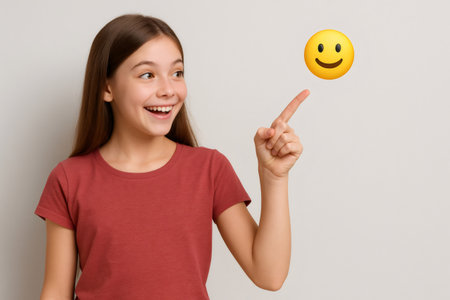 Young girl pointing her finger at a positive emoji, expressing happiness, satisfaction, and good feedbackの素材