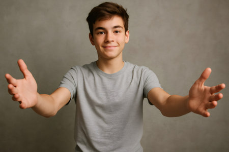 Smiling teenager opening arms wide for a warm hug, radiating affection and a welcoming gesture filled with joy and friendshipの素材