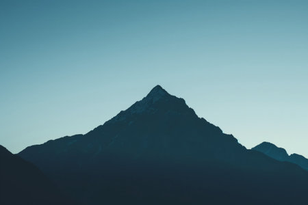 Minimalist photo capturing the silhouette of a mountain peak against a twilight skyの素材