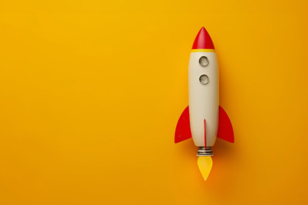 Vibrant illustration of a minimalist toy rocket with a playful design, set against a bold yellow backdropの素材