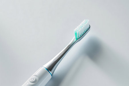 Sleek electric toothbrush with soft bristles, isolated on a clean white background with shadow detailの素材